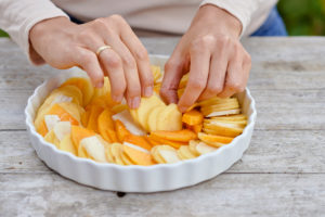 Prepare a gratin of potatoes, pumpkin and Jerusalem artichoke, arrange the sliced ingredients in a buttered baking pan Prepare a gratin of potatoes, pumpkin and Jerusalem artichoke, arrange the sliced ingredients in a buttered baking pan
